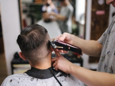 Back view of Men in beauty salon. Men's haircut in a barbershop. New haircut style 2021.