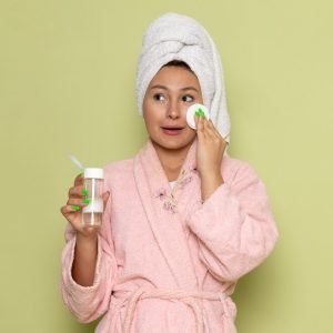 female-pink-bathrobe-cleaning-up-all-make-up-from-her-face_140725-25554